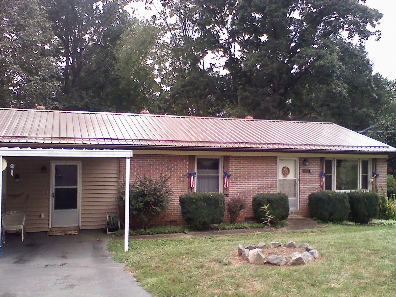 Bronze metal roof and carport on a brick ranch home — Roof Repair work by our crew in Ceresco